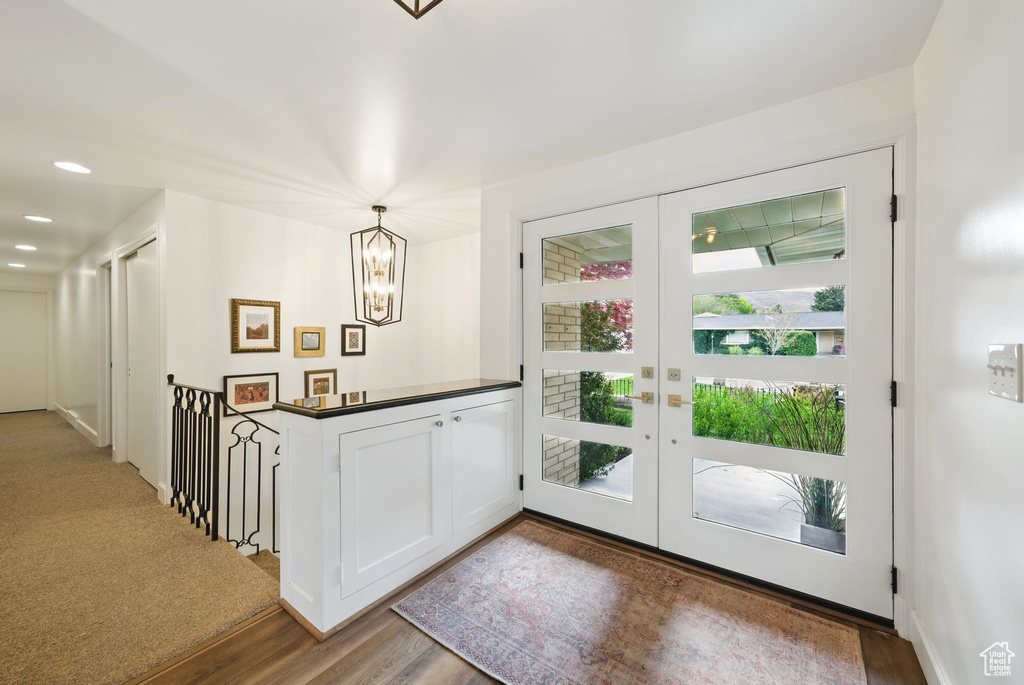 Interior space featuring french doors, recessed lighting, wood finished floors, and a notable chandelier