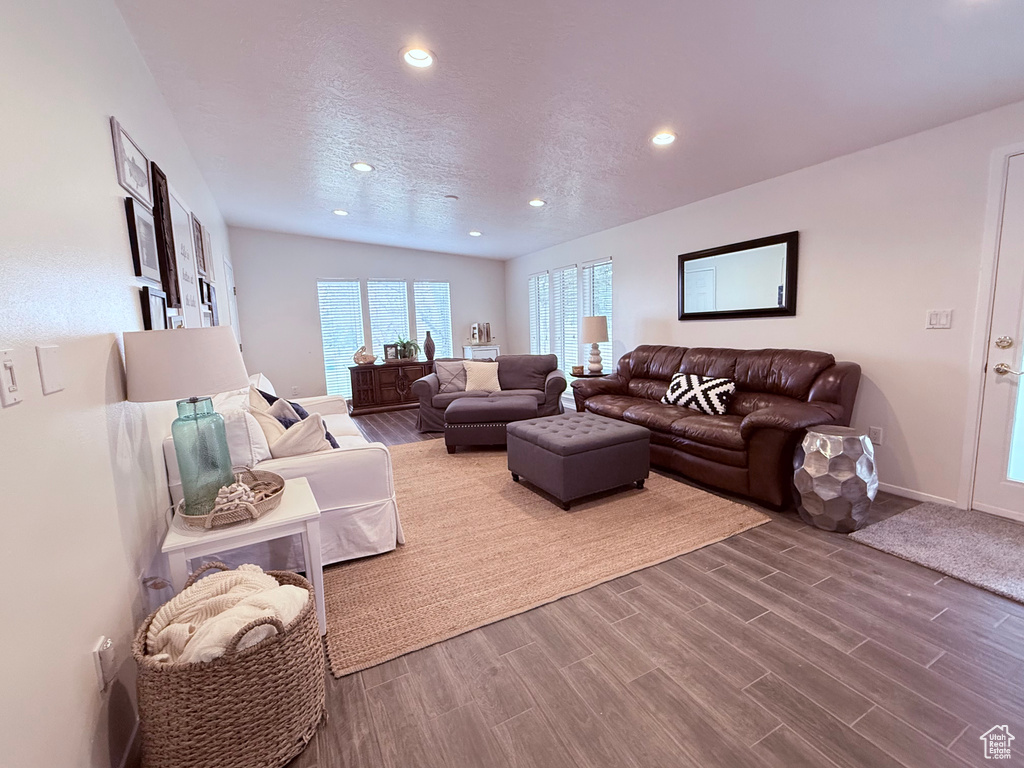 Living area with recessed lighting, baseboards, wood finished floors, and a textured ceiling