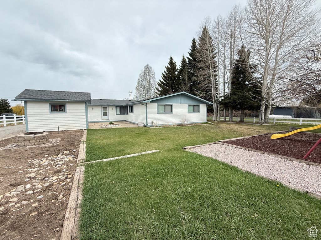 Rear view of property with a yard and fence