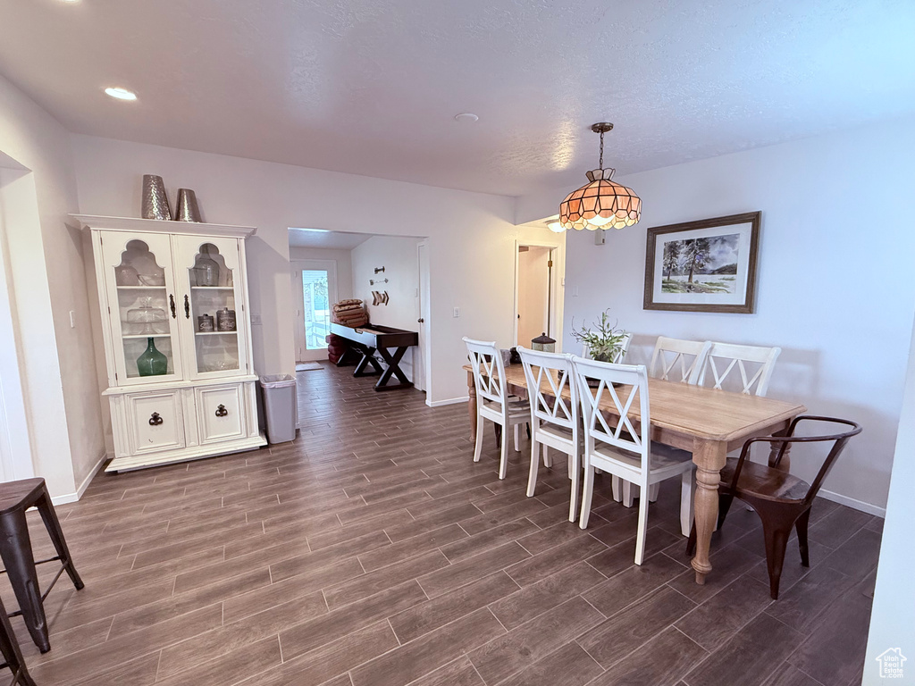 Dining area with baseboards and dark wood-style flooring