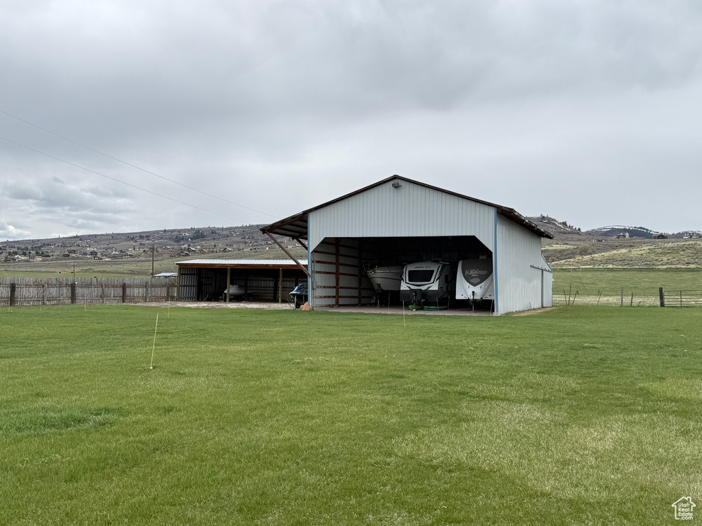 Back of property with fence, an outbuilding, and a yard