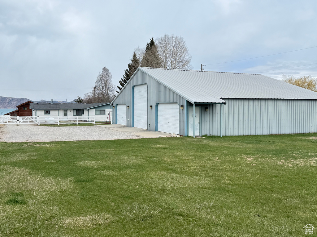 View of pole building with a yard