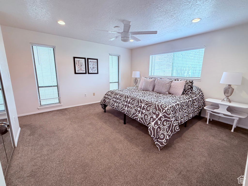 Carpeted bedroom with recessed lighting, a textured ceiling, ceiling fan, and baseboards
