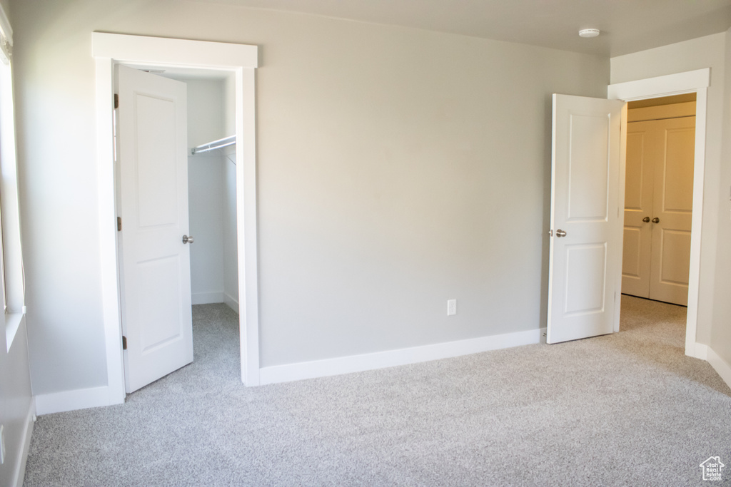 Unfurnished bedroom featuring carpet and a spacious closet