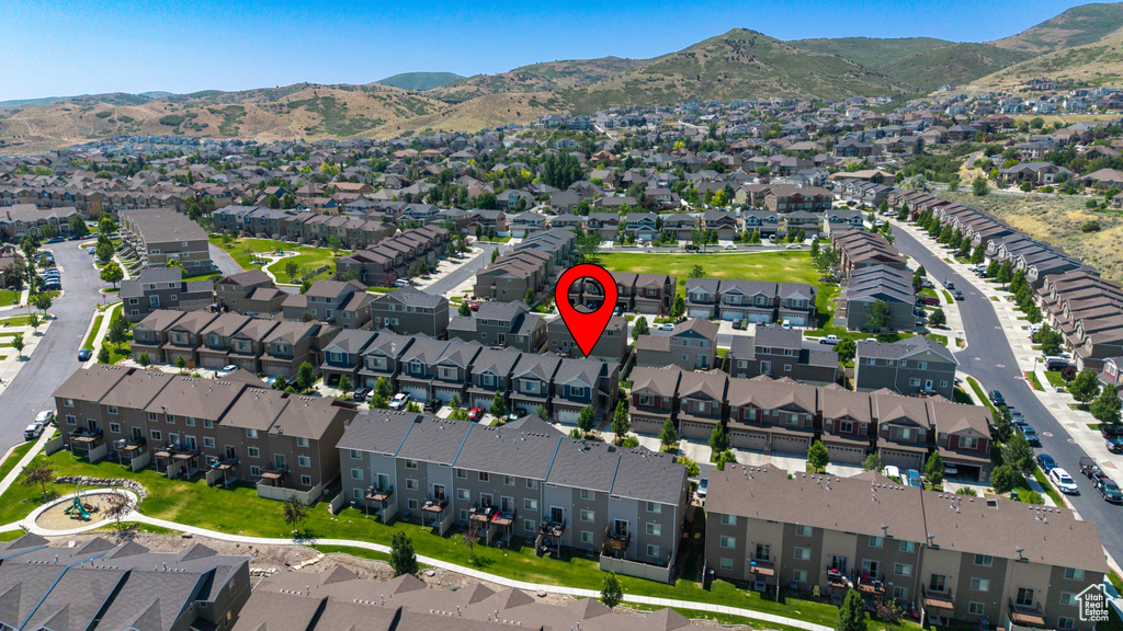 Aerial overview of property's location with a mountainous background and nearby suburban area