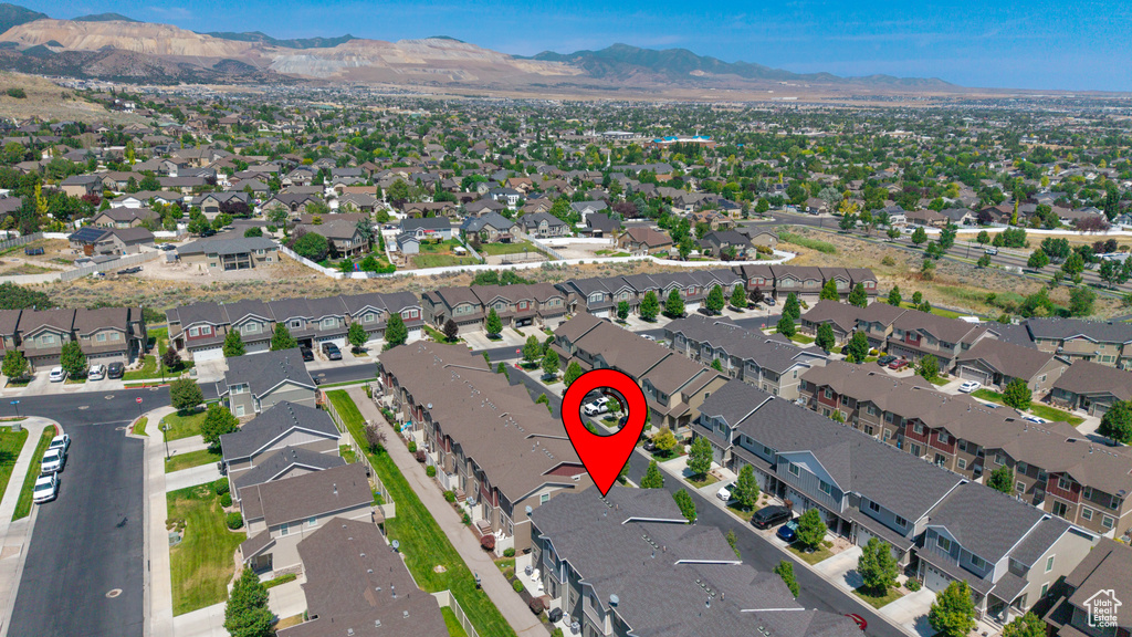 Aerial view of property and surrounding area with mountains and nearby suburban area