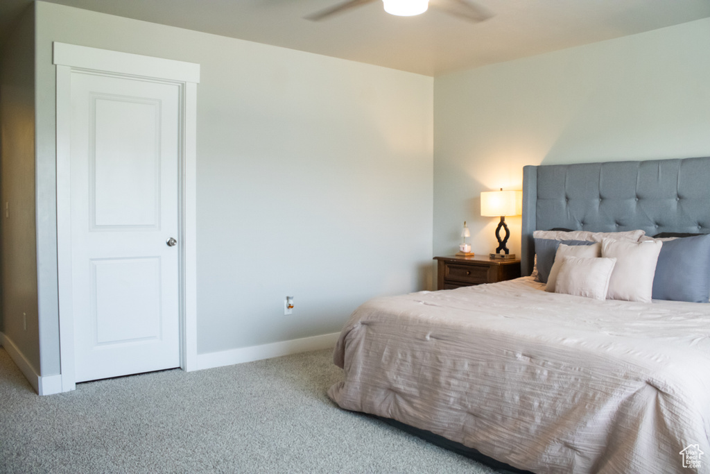 Carpeted bedroom with baseboards and a ceiling fan