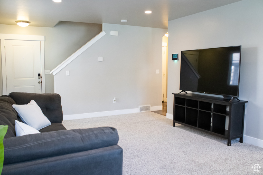 Living area with carpet, stairway, recessed lighting, and arched walkways