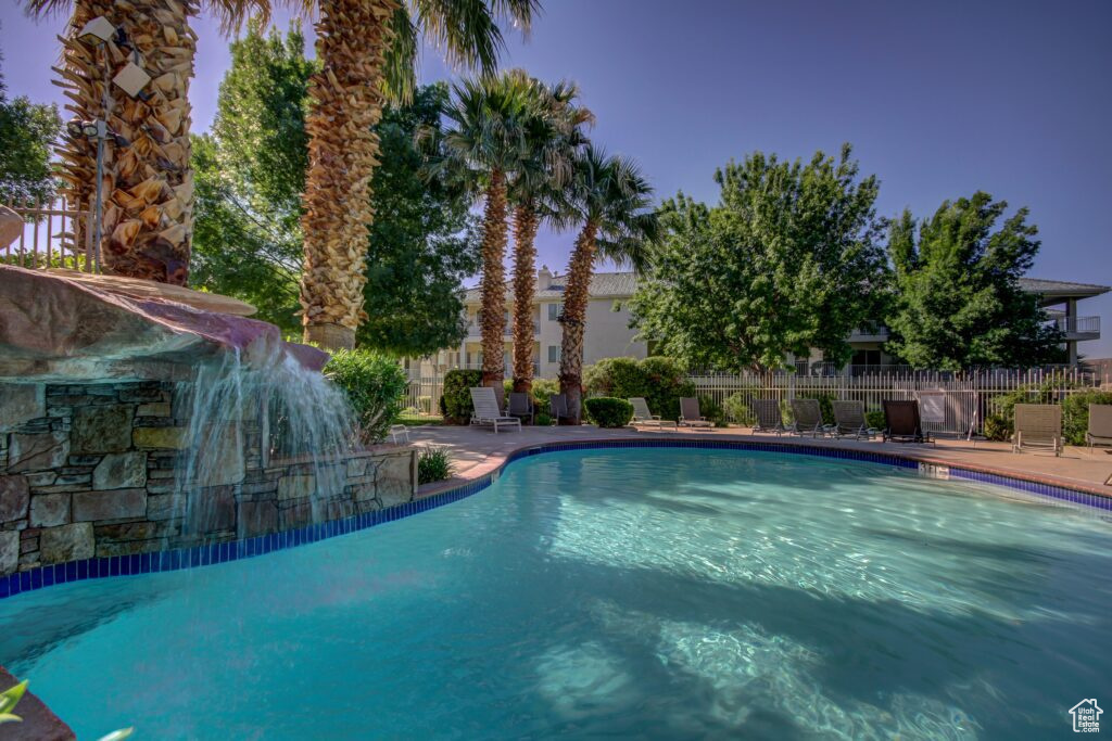 Community pool with a patio and fence