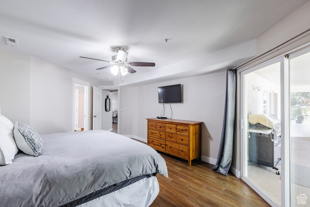 Bedroom with visible vents, wood finished floors, baseboards, ceiling fan, and access to outside