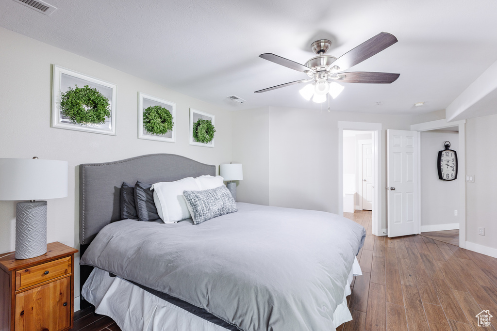 Bedroom with visible vents, a ceiling fan, baseboards, and wood finished floors