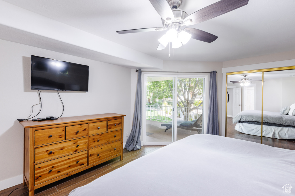 Bedroom with a closet, wood finished floors, access to exterior, baseboards, and ceiling fan