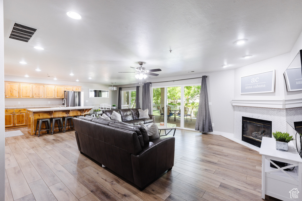 Living area featuring recessed lighting, ceiling fan, visible vents, and light wood-style flooring