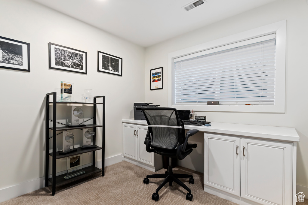 Office with visible vents, baseboards, and light carpet
