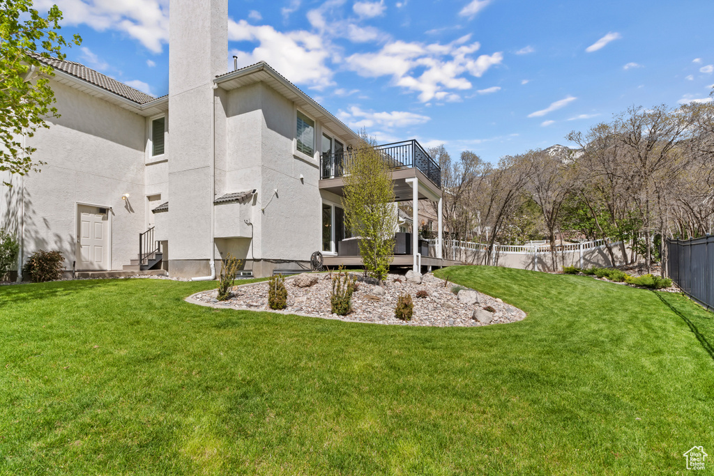 View of yard featuring a balcony and fence