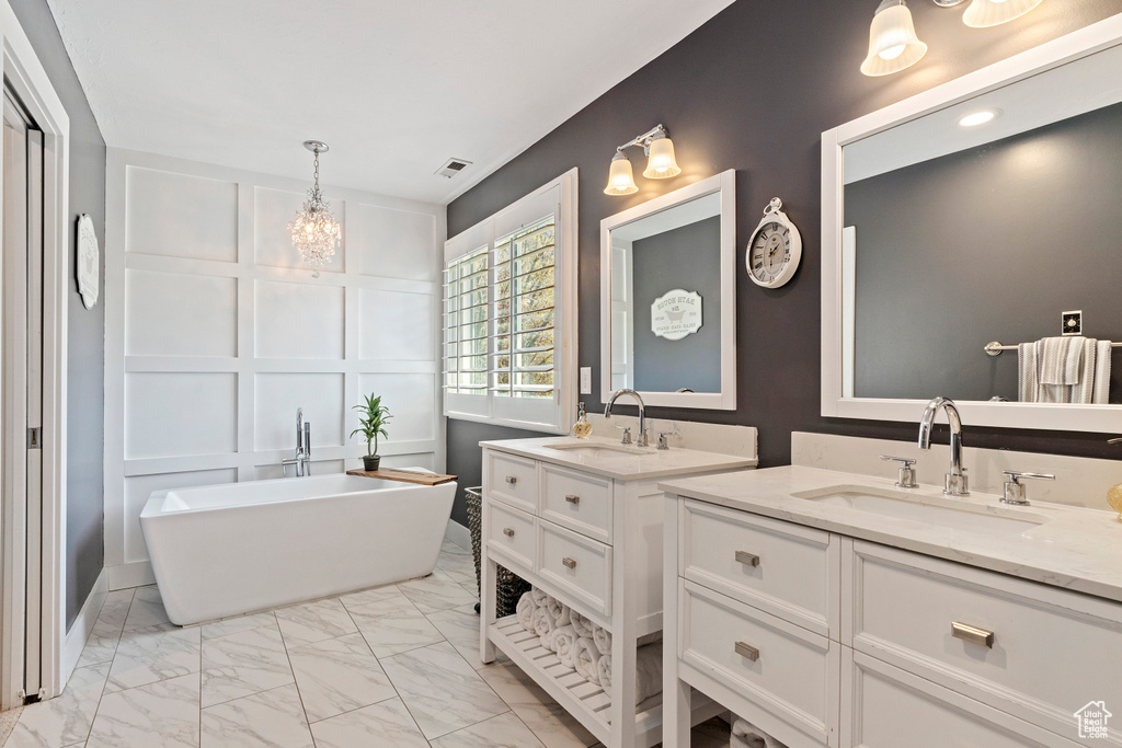 Full bath with visible vents, a soaking tub, marble finish floor, and a sink