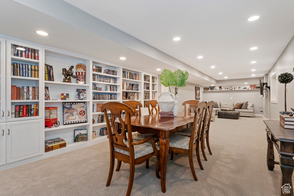 Dining space featuring built in shelves, recessed lighting, and light carpet