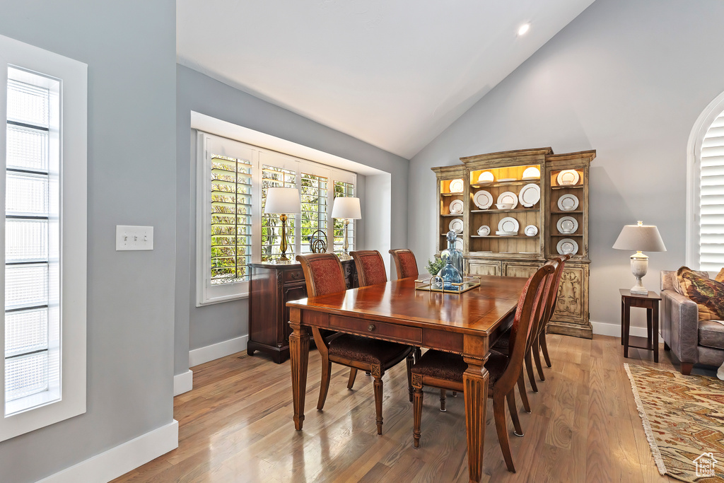 Dining space with baseboards, light wood-type flooring, recessed lighting, and vaulted ceiling