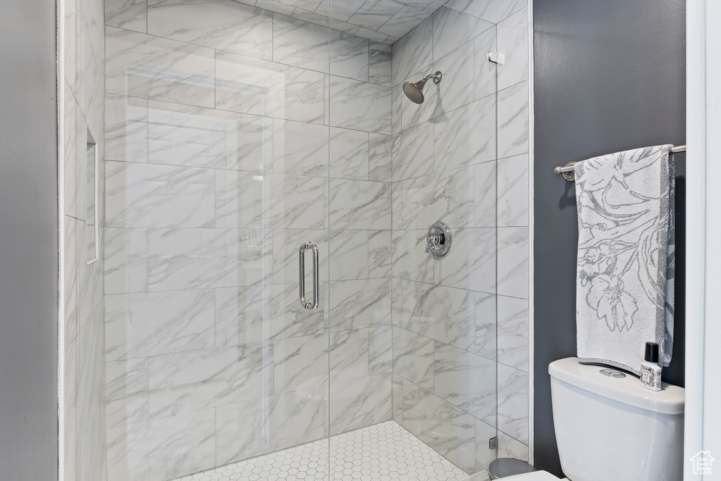 Full bathroom featuring a stall shower and toilet