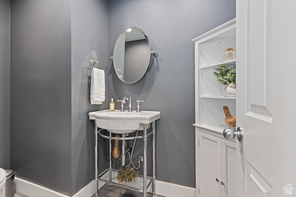 Half bathroom with toilet and baseboards