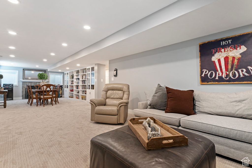 Living area with built in shelves, recessed lighting, and light colored carpet