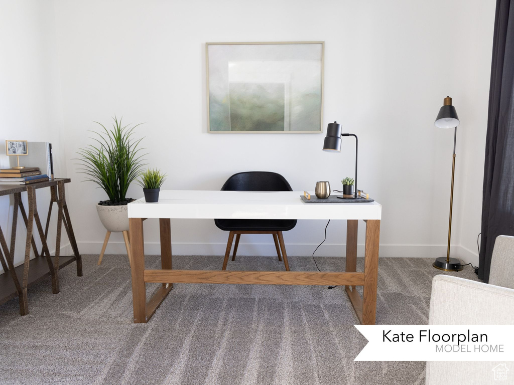 Carpeted home office featuring baseboards