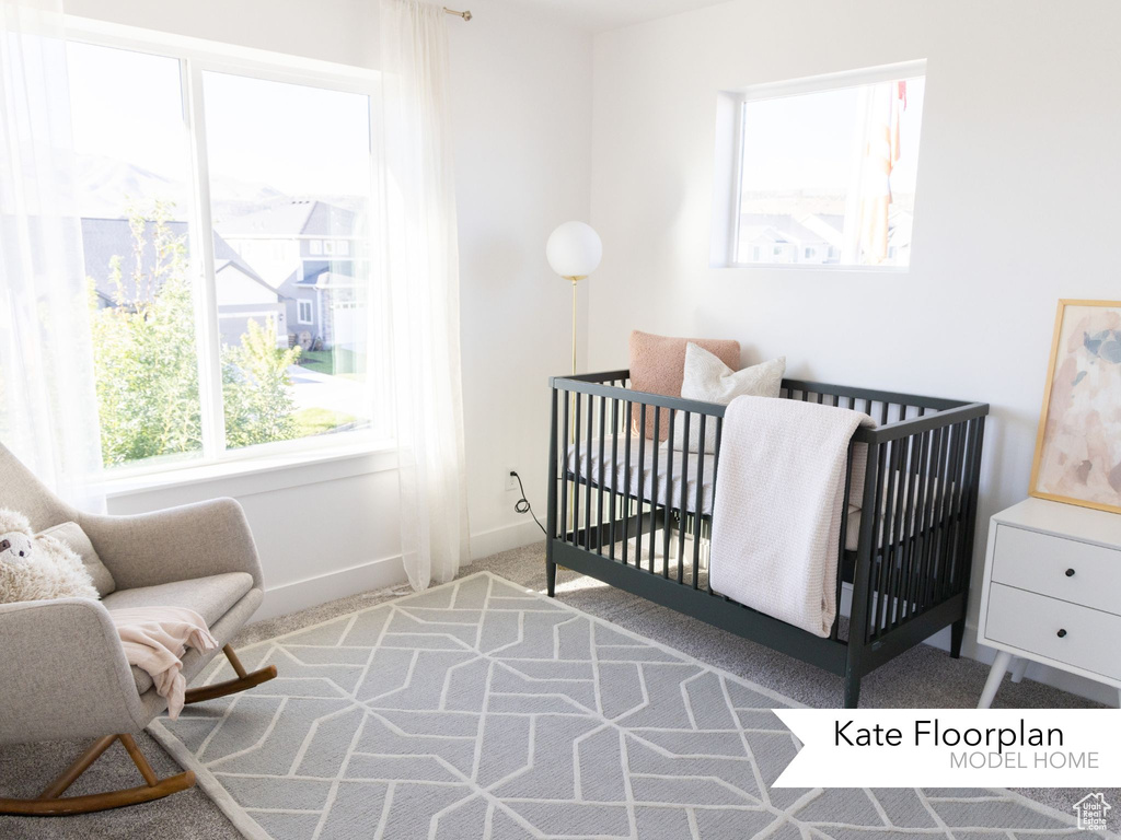 Bedroom with carpet flooring, baseboards, and a crib