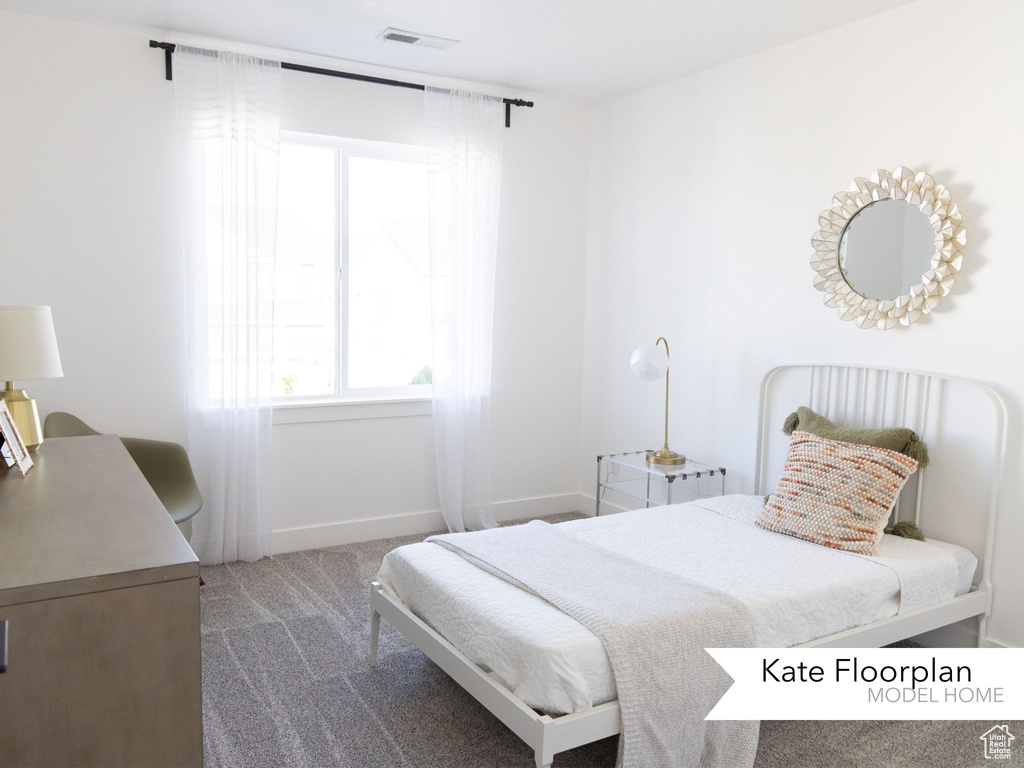 Bedroom with carpet floors, baseboards, visible vents, and multiple windows