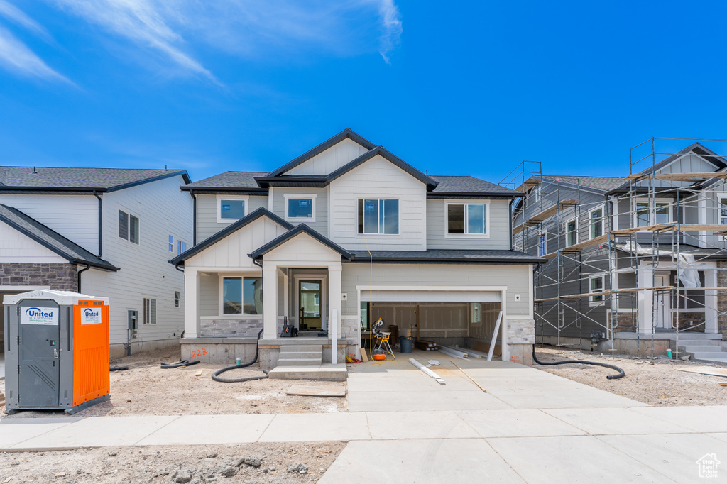 View of front of house featuring driveway, board and batten siding, and a garage