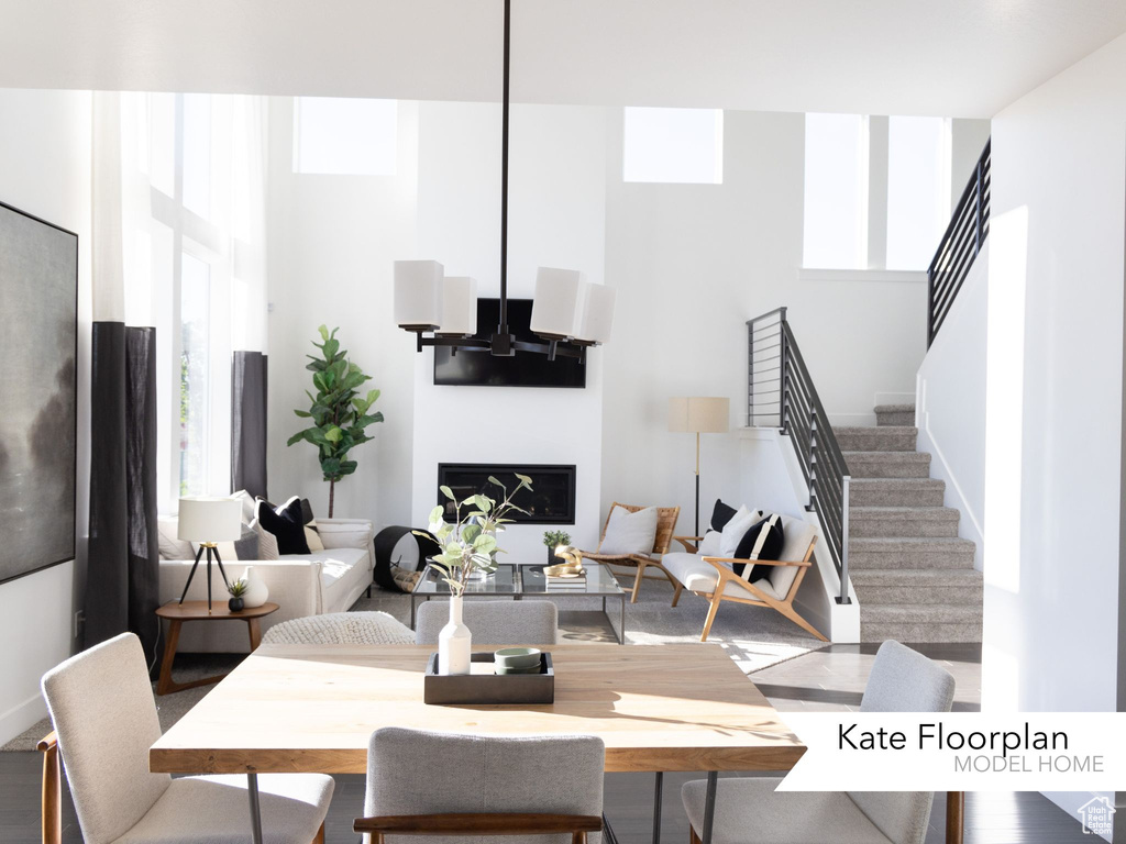 Dining area featuring stairs, a wealth of natural light, and a towering ceiling