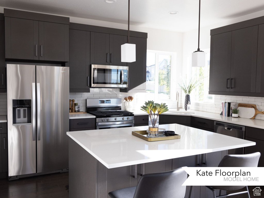 Kitchen with appliances with stainless steel finishes, a kitchen breakfast bar, and backsplash