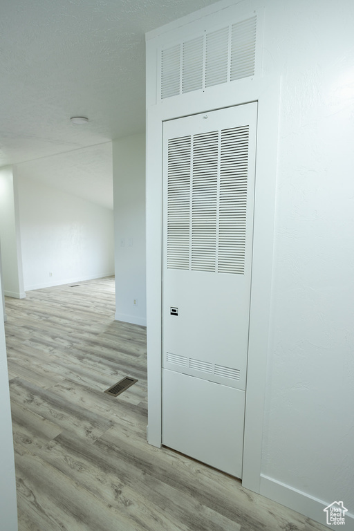 Interior details featuring visible vents, a heating unit, baseboards, and wood finished floors