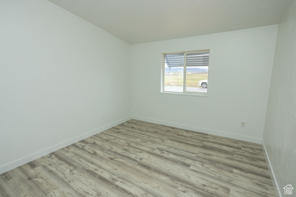 Unfurnished room with light wood-style floors and baseboards