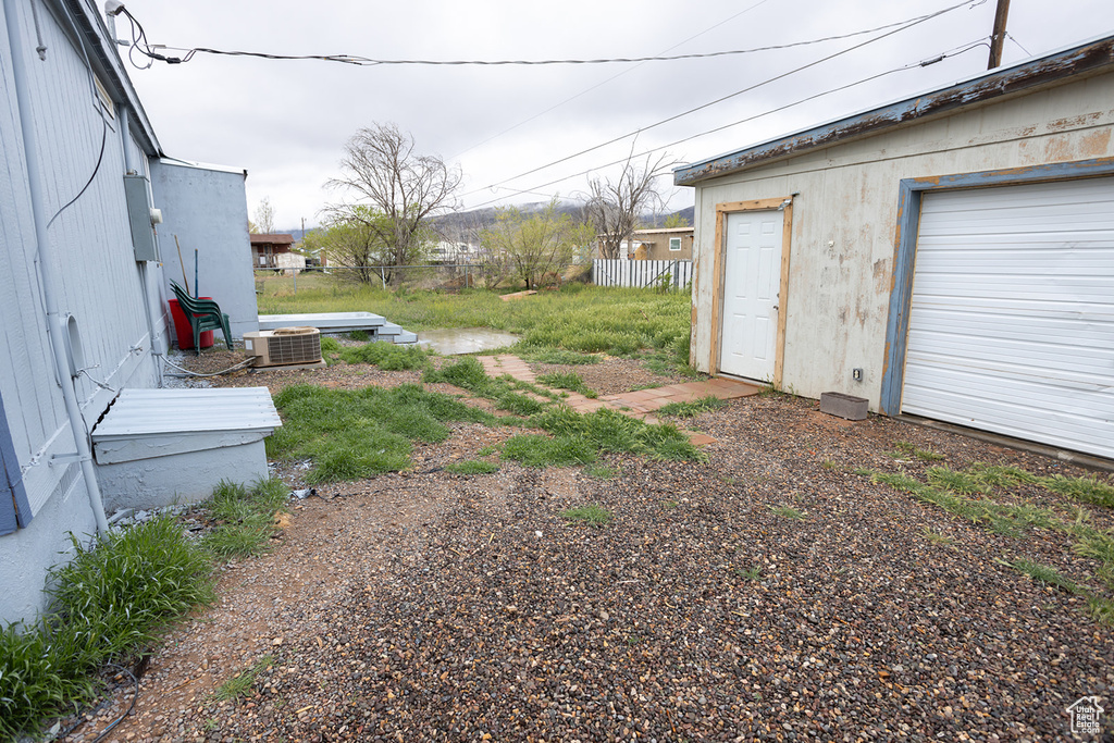 View of yard with central AC unit and fence