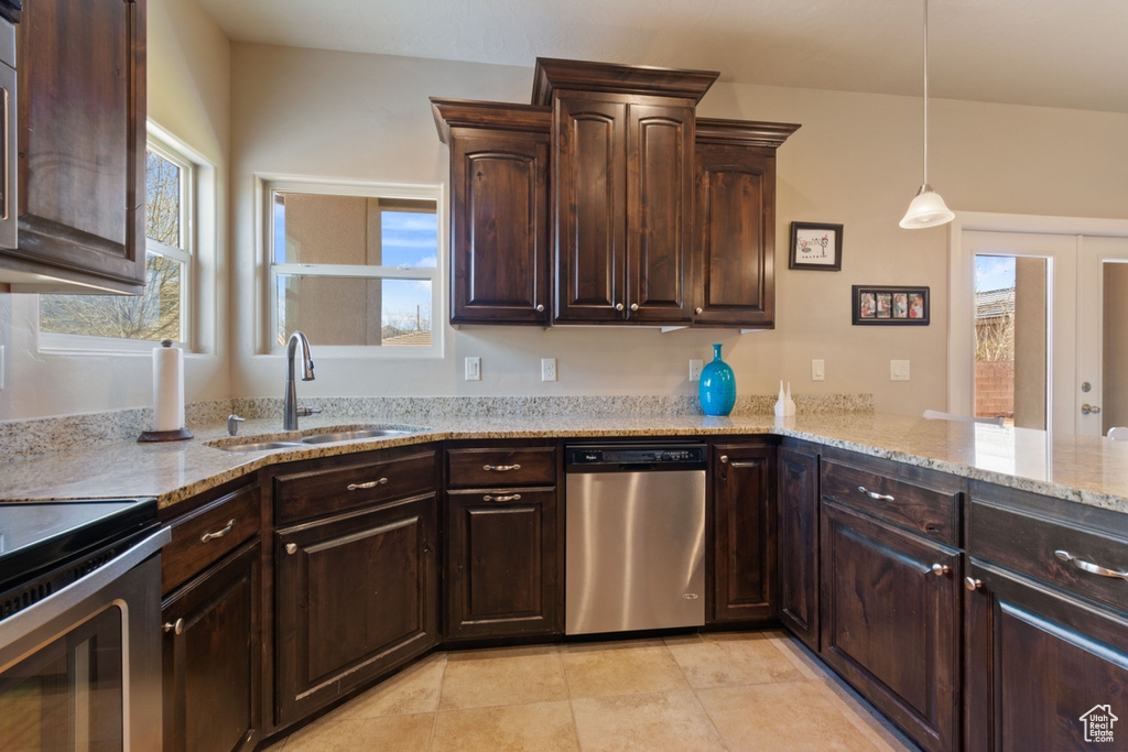 Kitchen with light stone countertops, dishwasher, pendant lighting, light tile floors, and sink
