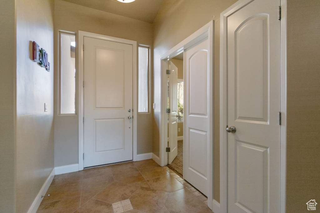 Entrance foyer featuring light tile floors and a healthy amount of sunlight