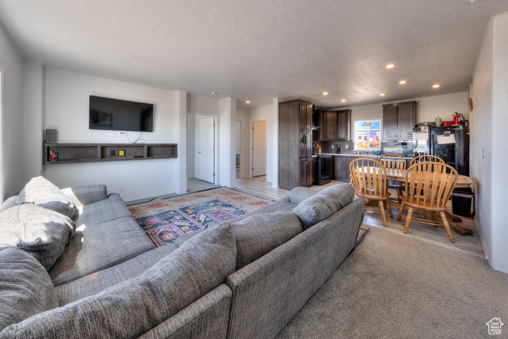 Living area with light wood-style floors and recessed lighting