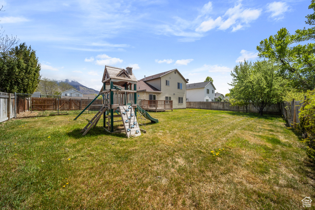 View of yard featuring a playground and a fenced backyard