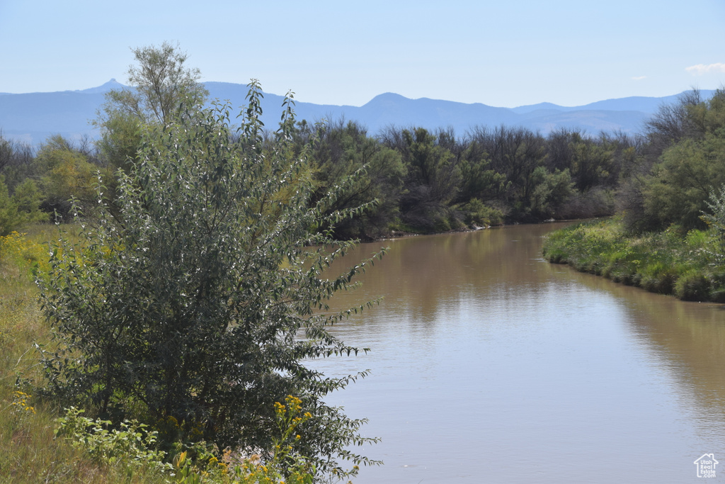 Property view of water with a forest view and a mountain view