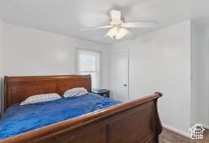Carpeted bedroom featuring baseboards and ceiling fan