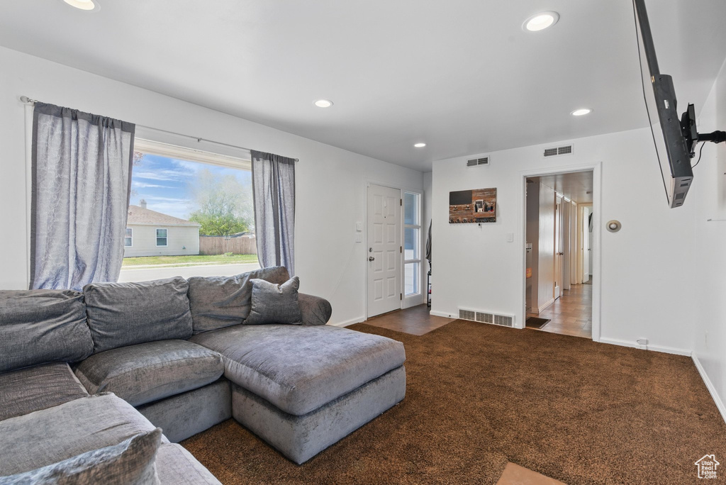 Living area with carpet, visible vents, recessed lighting, and baseboards