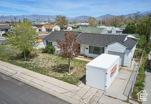 Ranch-style home featuring a garage, concrete driveway, and a mountain view