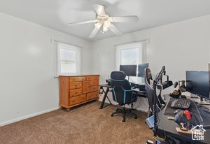 Office featuring healthy amount of natural light, carpet flooring, a ceiling fan, and baseboards