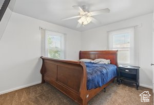 Carpeted bedroom featuring baseboards and a ceiling fan