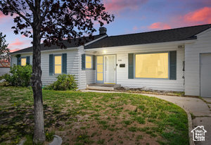 Ranch-style home featuring a garage, driveway, and a yard