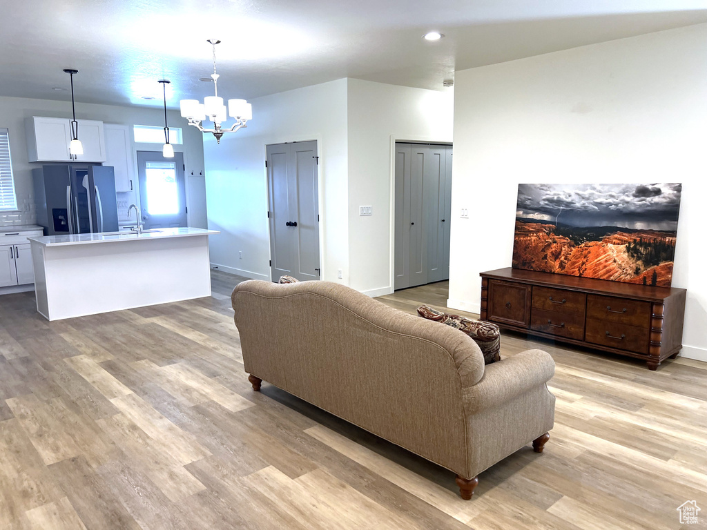 Living area with an inviting chandelier and light wood finished floors