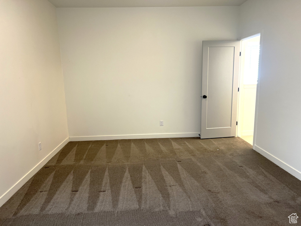 Empty room with carpet floors and baseboards