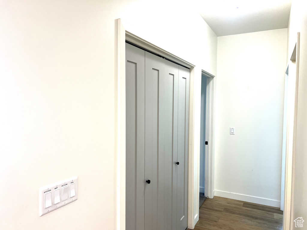 Hallway with baseboards and dark wood-style flooring