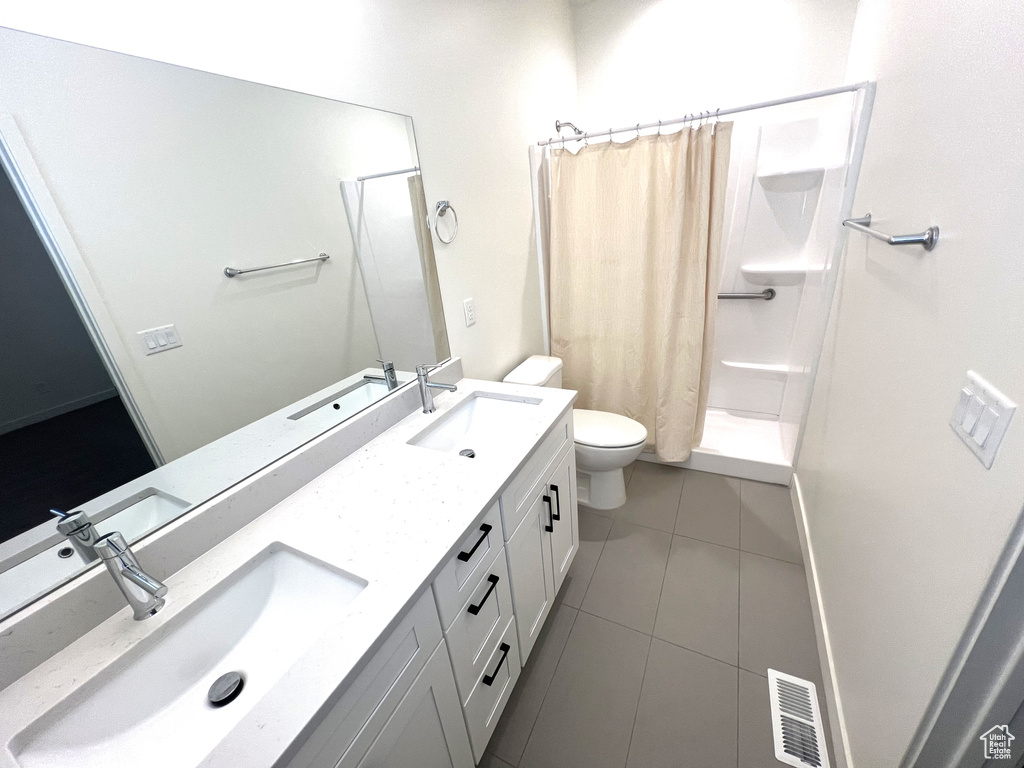 Bathroom with visible vents, a sink, tile patterned floors, and toilet