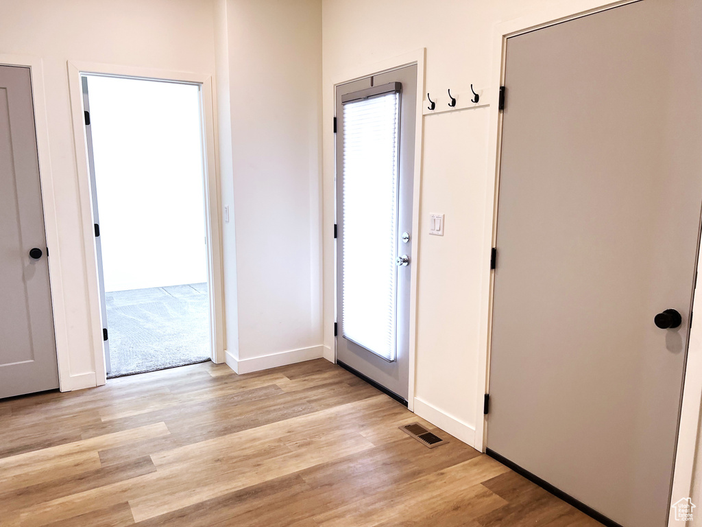 Doorway featuring visible vents, baseboards, and light wood-type flooring